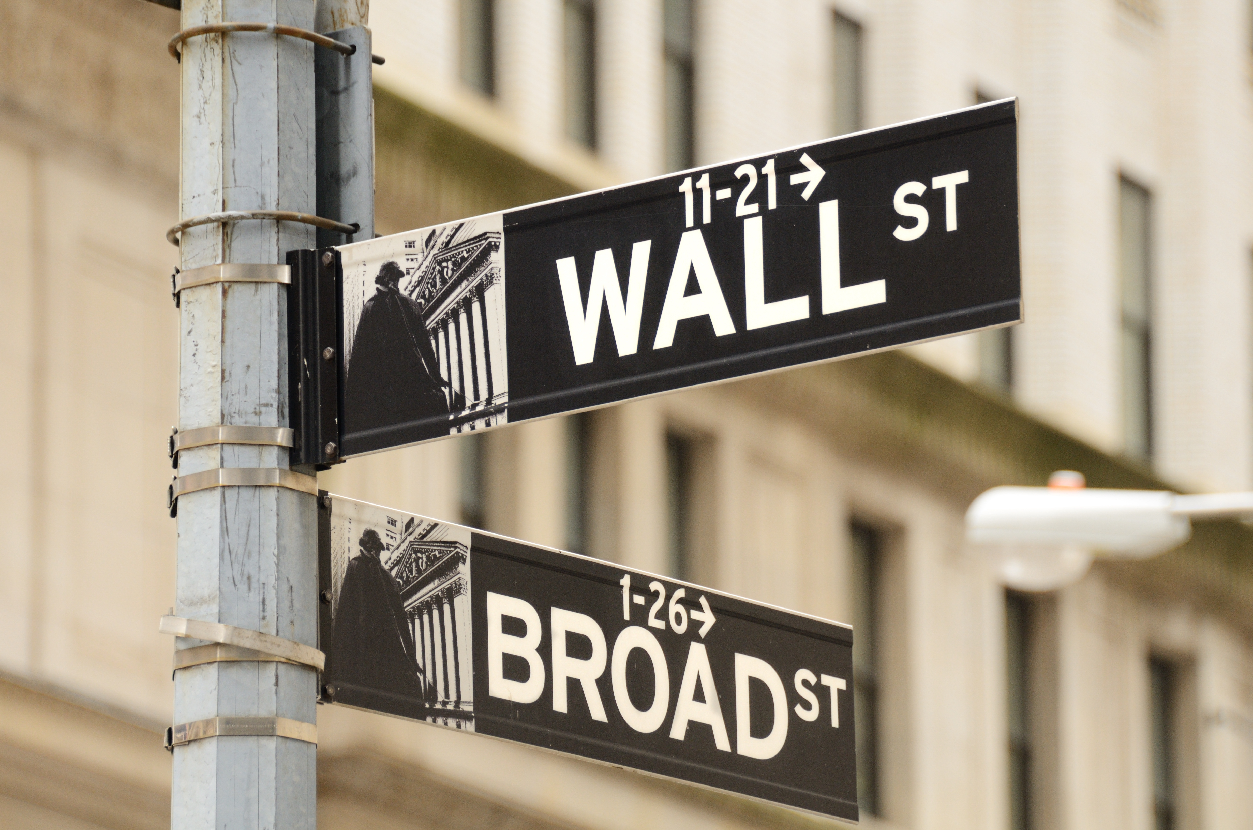 Street sign for Wall Street and Broad Street, the heart of the Financial District of New York City. Image courtesy of Adobe Stock.